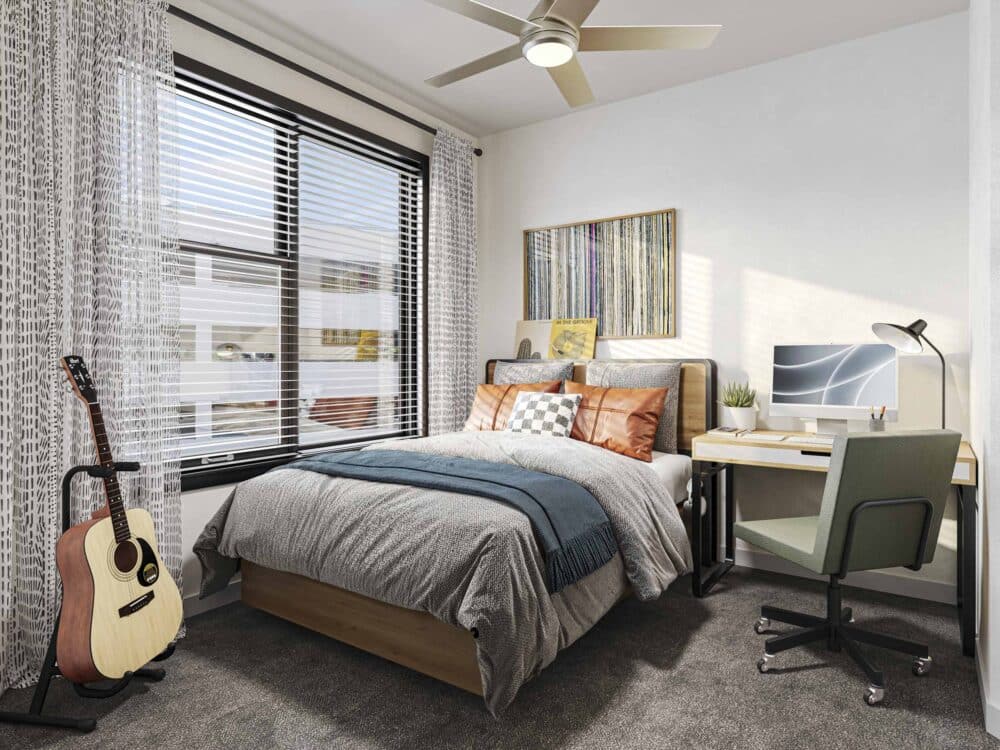 stylish bedroom with bed and a desk with a computer and chair